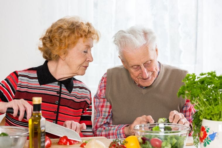 Senior couple preparing green salad for a ckd plant-based diet