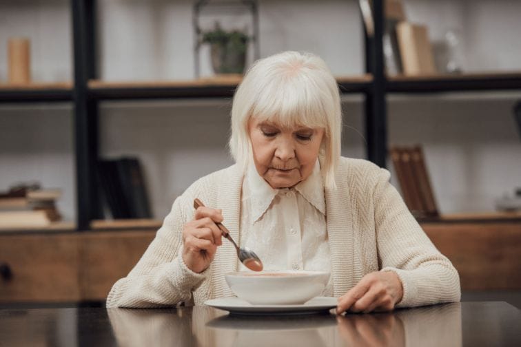 Senior woman eating alone