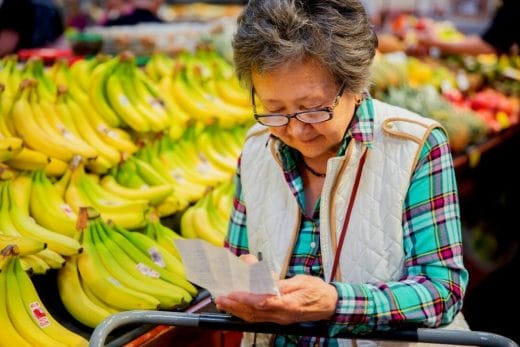 old woman looking at a grocery list