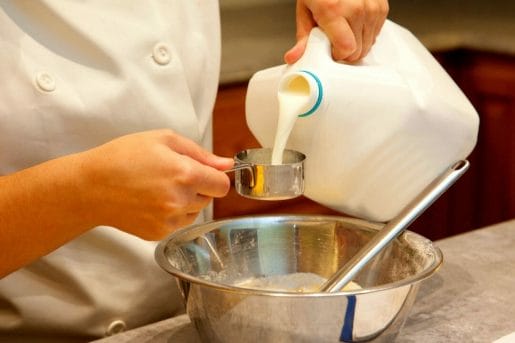 milk pouring in a measuring cup