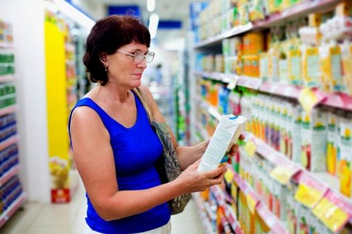old woman in grocery looking at food label