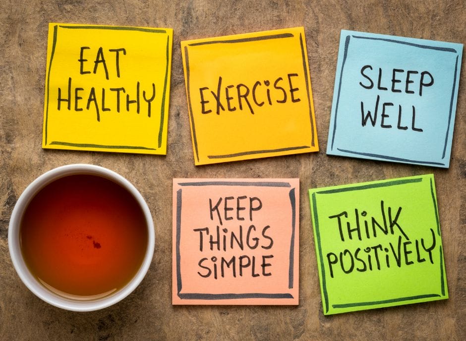 Four sticky notes with the words eat exercise well keep things positive.