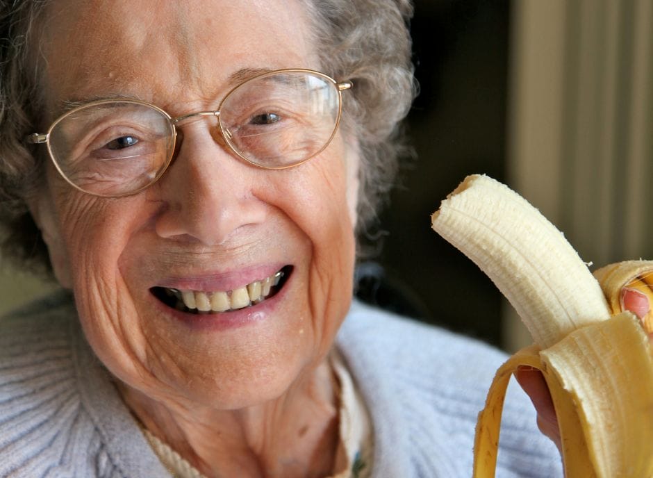A woman is holding a banana.