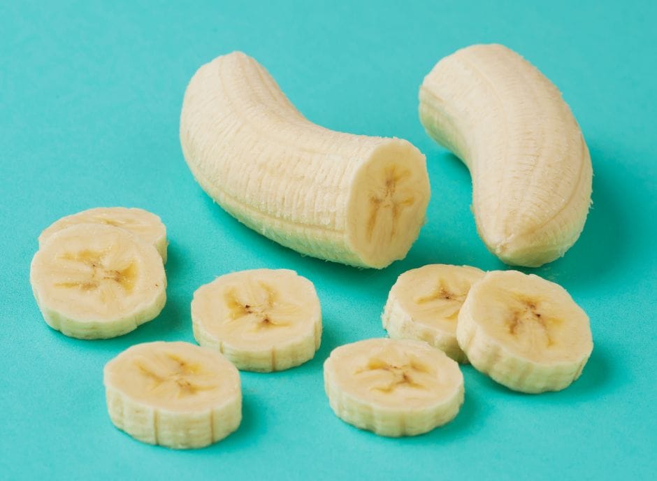 Sliced bananas on a turquoise background.