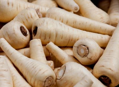 A close up of a pile of root vegetables.