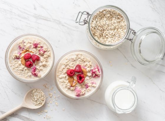 Oats in jars with raspberries and milk.