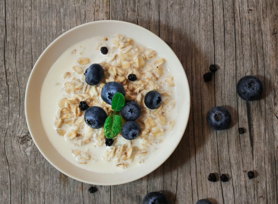 Oatmeal with blueberries and mint on a wooden table.