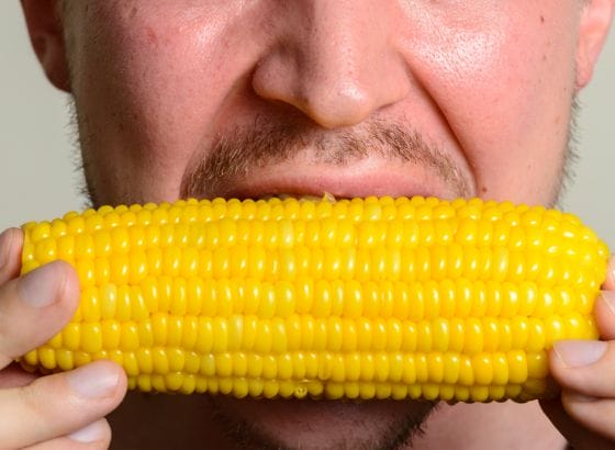 A man with CKD is enjoying a corn on the cob.