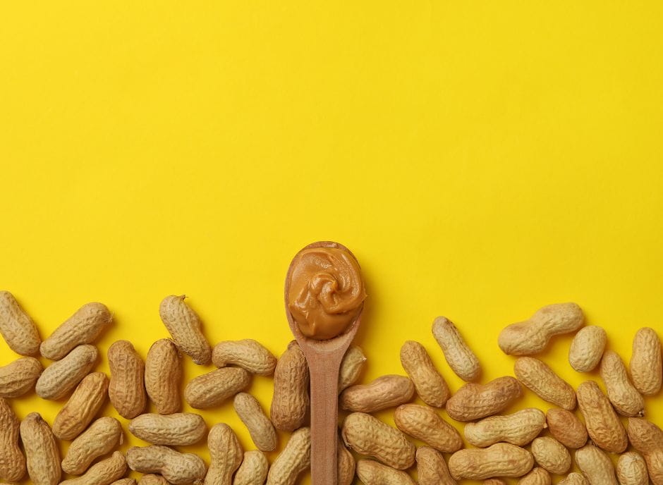 Peanuts and peanut butter on a yellow background, suitable for a renal diet.
