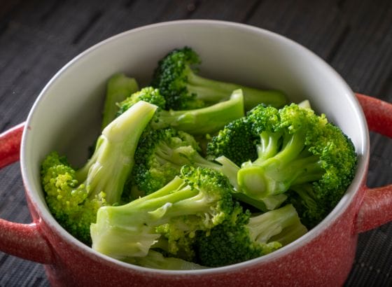 A bowl full of broccoli, a nutritious vegetable suitable for a renal diet, on a table.