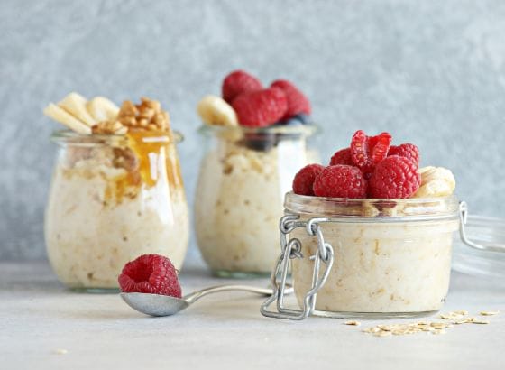 Oatmeal in jars with raspberries and nuts.