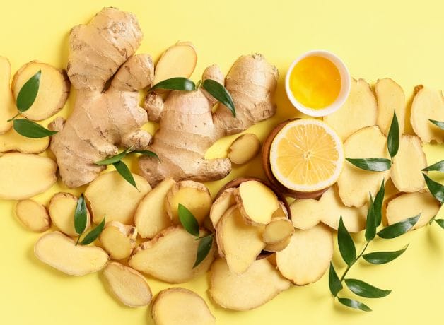 Ginger slices and leaves on a yellow background.