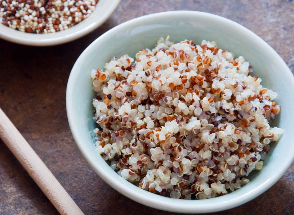 A nourishing bowl of quinoa, served alongside a wooden spoon, highlights the benefits of quinoa for kidney health.