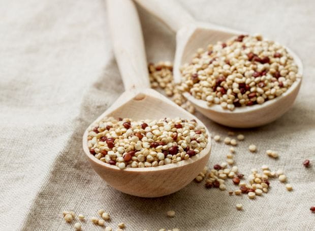 Two wooden spoons filled with sesame seeds, a nutritious addition for quinoa recipes and promoting kidney health.