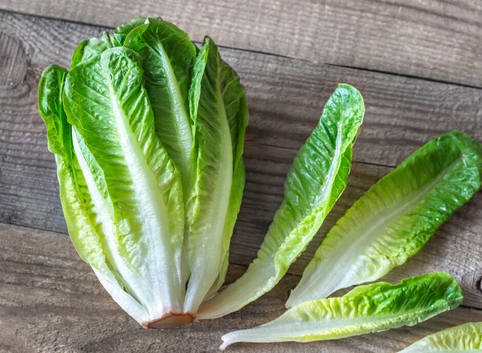 Fresh romaine lettuce on a wooden surface.