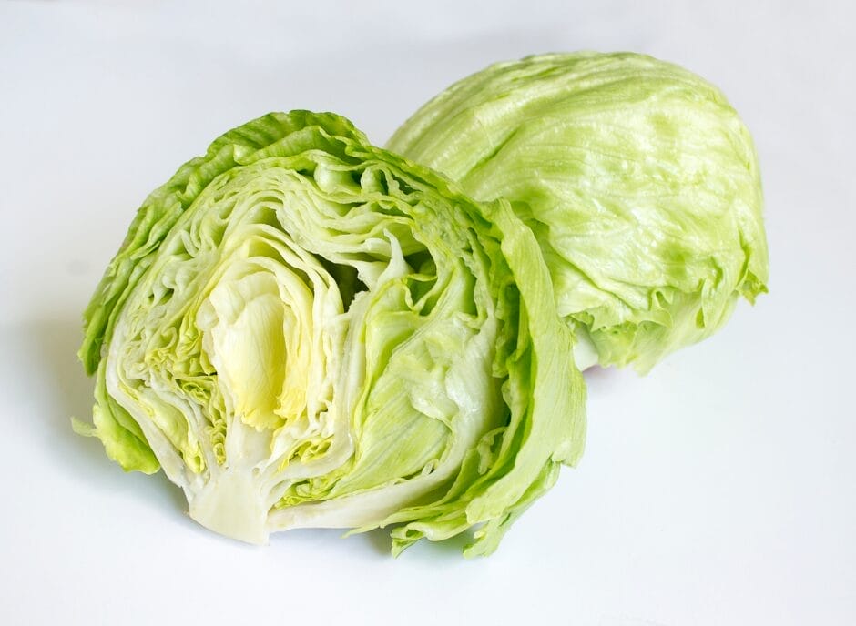 Two halves of a head of iceberg lettuce on a white background.